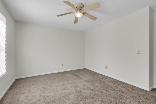 unfurnished room featuring carpet floors, ceiling fan, and baseboards