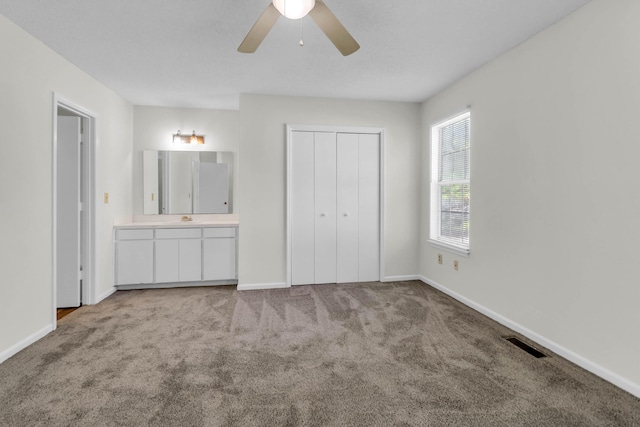 unfurnished bedroom with carpet floors, a closet, visible vents, and baseboards