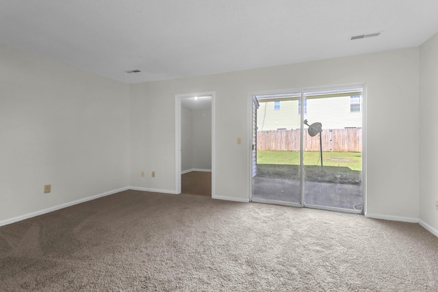 carpeted empty room featuring visible vents and baseboards