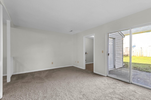 carpeted empty room featuring baseboards