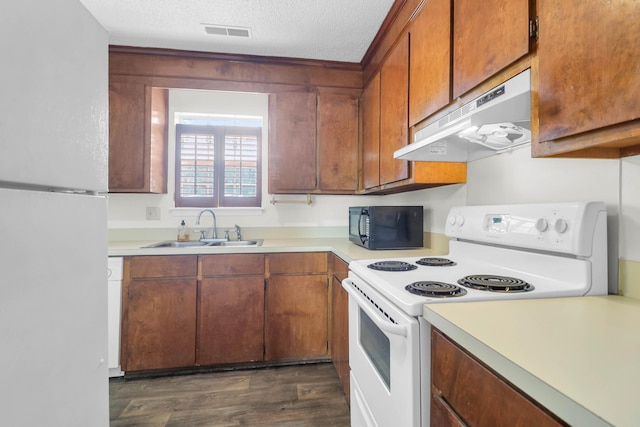 kitchen featuring under cabinet range hood, white appliances, a sink, visible vents, and light countertops