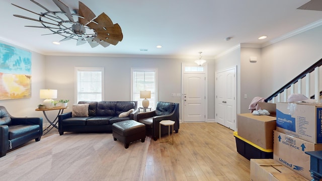 living room featuring ceiling fan, ornamental molding, and light hardwood / wood-style flooring