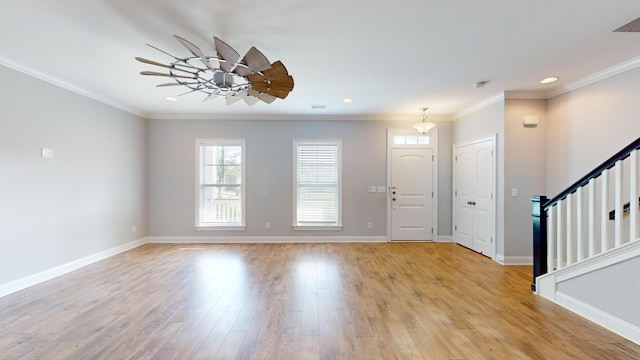 foyer featuring crown molding, ceiling fan, and light wood-type flooring