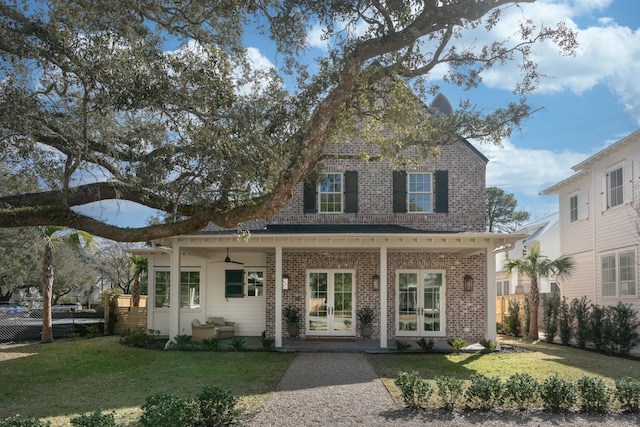 view of front facade featuring french doors, a porch, ceiling fan, and a front lawn