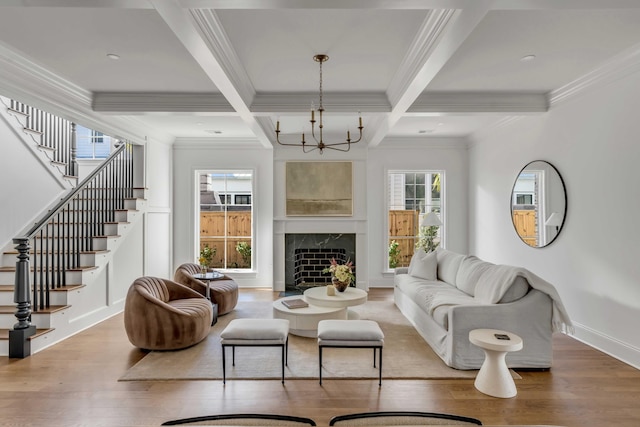 living room featuring wood-type flooring, ornamental molding, and beamed ceiling