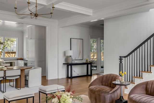 living room with crown molding, an inviting chandelier, coffered ceiling, wood-type flooring, and beamed ceiling