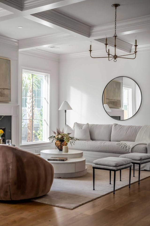 living room featuring hardwood / wood-style flooring, ornamental molding, coffered ceiling, and beamed ceiling