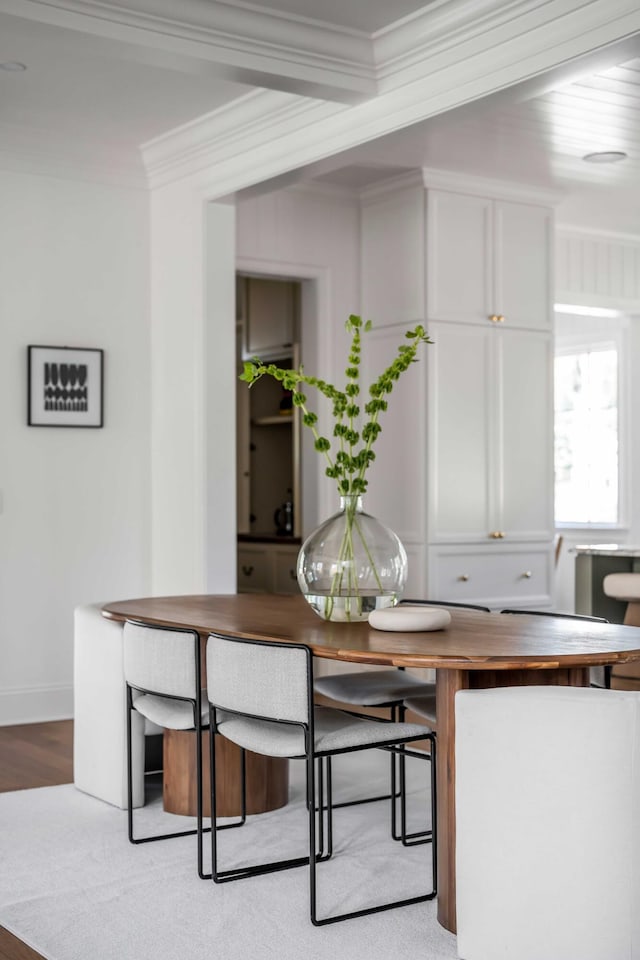 dining space featuring ornamental molding and light hardwood / wood-style flooring