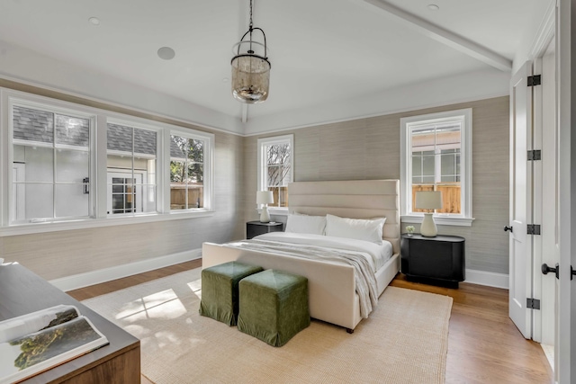 bedroom featuring beamed ceiling and light hardwood / wood-style flooring