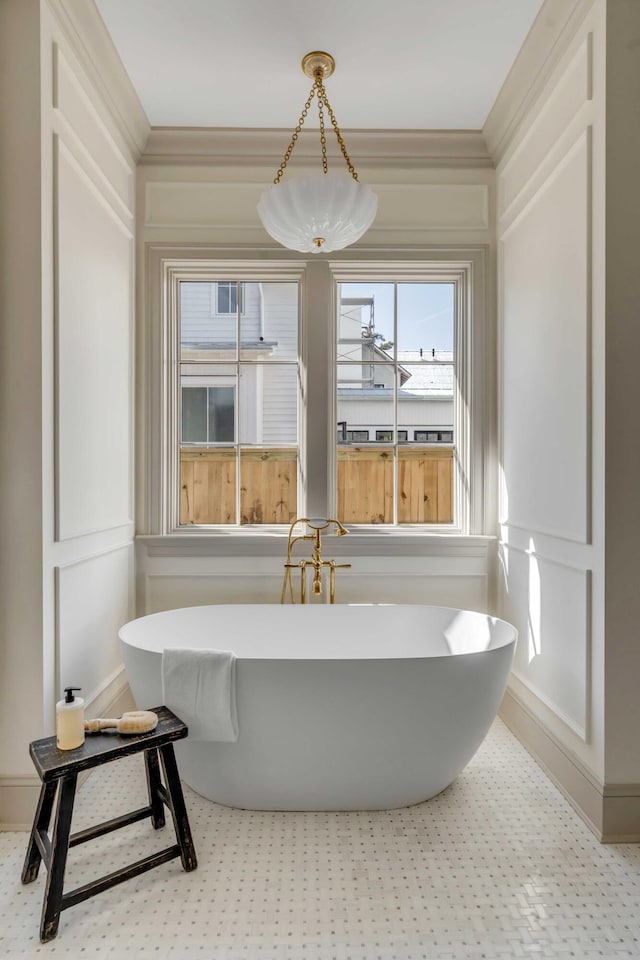 bathroom featuring a tub to relax in and ornamental molding