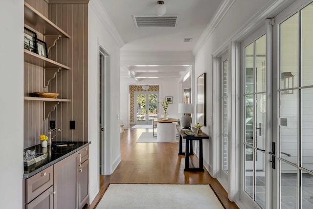 bar with crown molding, sink, hardwood / wood-style floors, and french doors