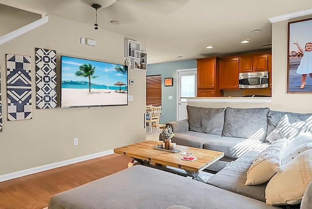 living area with baseboards, wood finished floors, and recessed lighting
