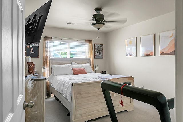 carpeted bedroom featuring a ceiling fan and visible vents