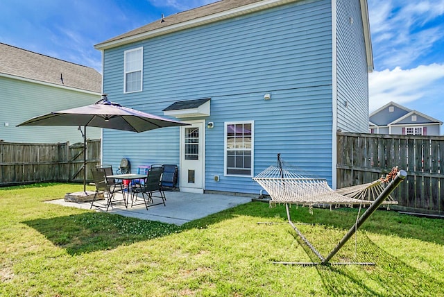 back of house featuring a yard, a patio, and a fenced backyard