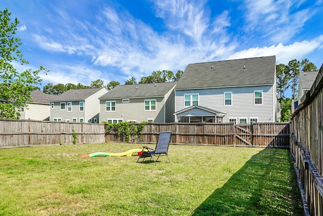 back of house with a residential view, a lawn, and a fenced backyard