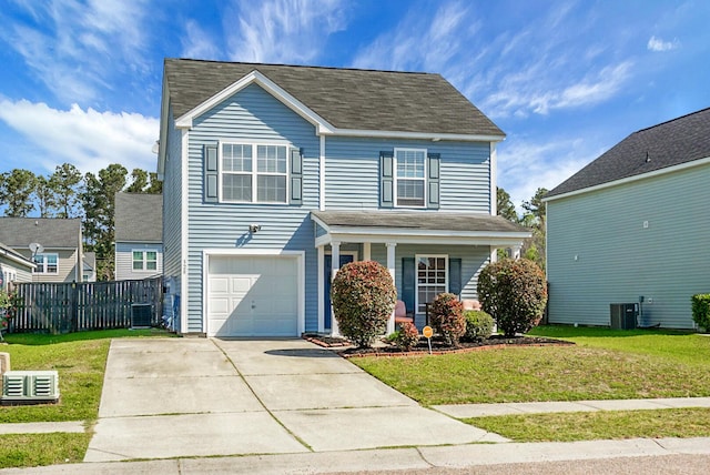 traditional-style home featuring a front lawn, fence, driveway, and a garage