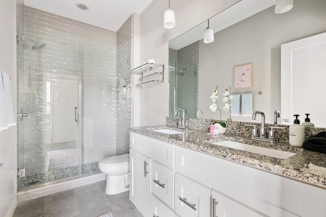 full bath with a sink, toilet, double vanity, and a shower stall