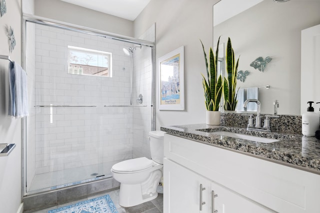 full bath featuring toilet, a stall shower, vanity, and tile patterned flooring