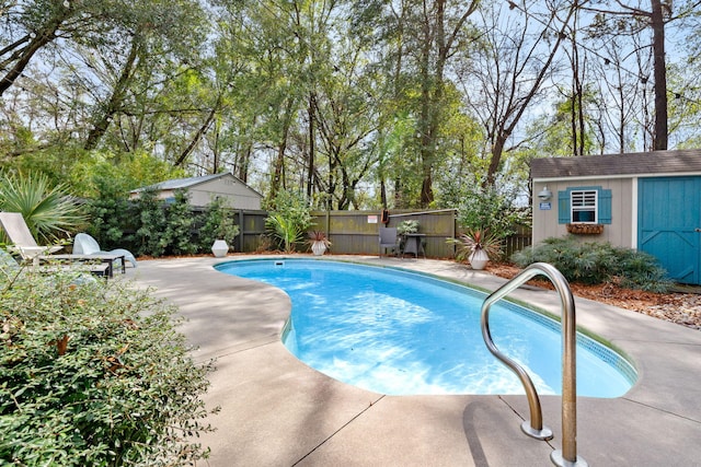 view of pool featuring a storage unit, a fenced backyard, an outdoor structure, a fenced in pool, and a patio area