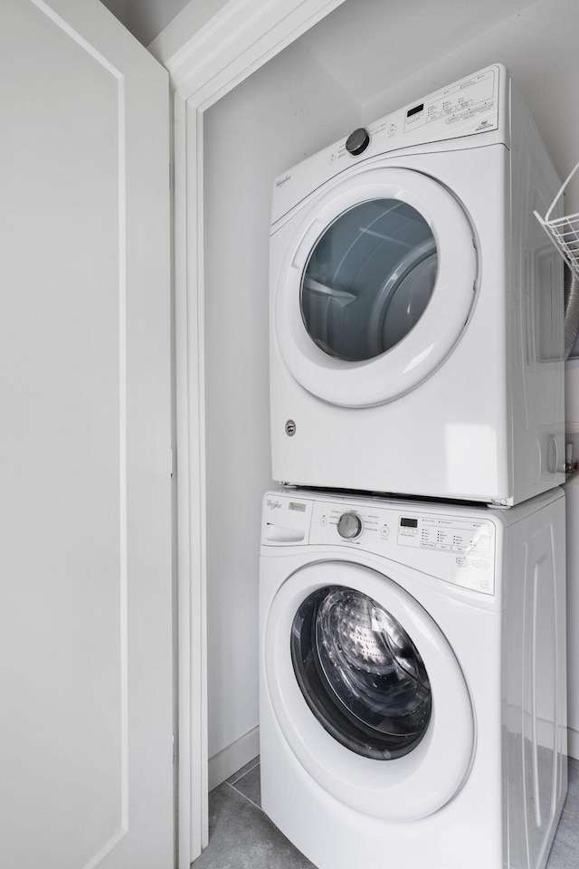 laundry area featuring laundry area, stacked washer and dryer, and tile patterned floors