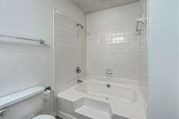 bathroom featuring shower / tub combination and toilet