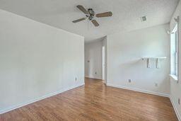 unfurnished room featuring ceiling fan, baseboards, a healthy amount of sunlight, and wood finished floors