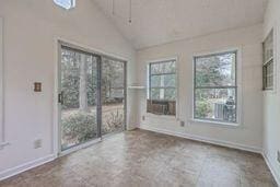 unfurnished room featuring baseboards and vaulted ceiling