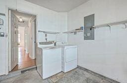 laundry area featuring laundry area, electric panel, and washing machine and clothes dryer