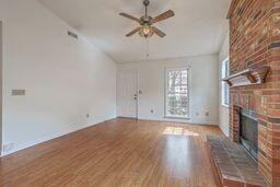 unfurnished living room featuring wood finished floors, a fireplace, lofted ceiling, and ceiling fan