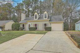 cape cod house with driveway, a front yard, and a garage