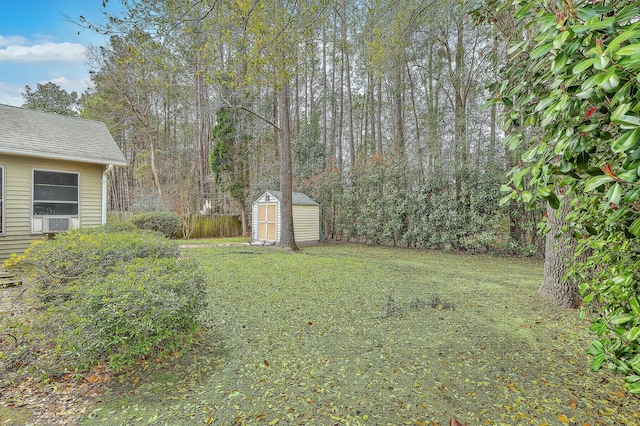 view of yard with a forest view, a storage unit, and an outdoor structure