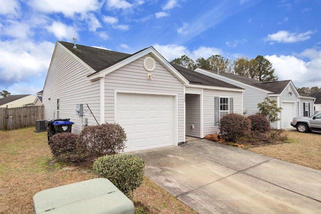 view of front facade with an attached garage, driveway, fence, and a front lawn