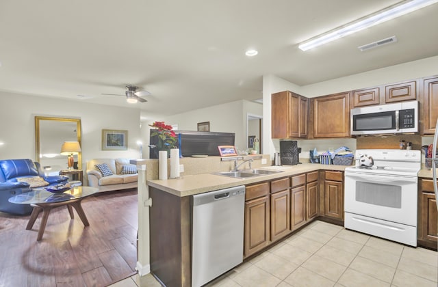 kitchen featuring stainless steel appliances, light countertops, visible vents, open floor plan, and a sink