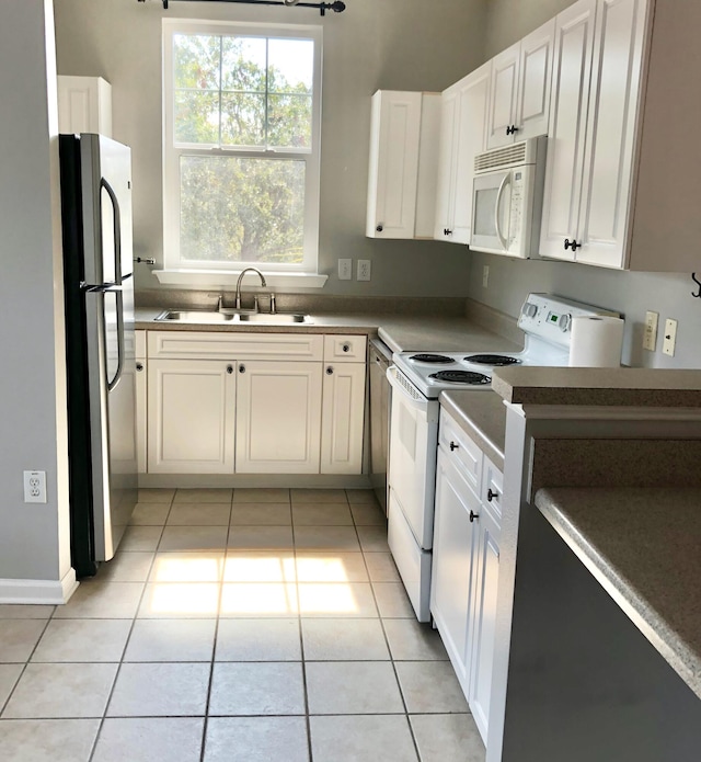 kitchen with white cabinets, light tile patterned flooring, sink, and stainless steel appliances