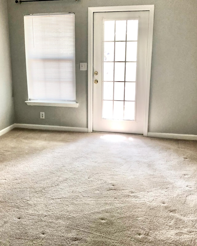 doorway with carpet and a healthy amount of sunlight