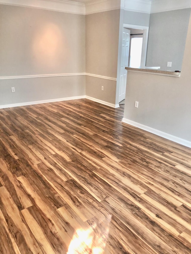 unfurnished room featuring wood-type flooring and ornamental molding