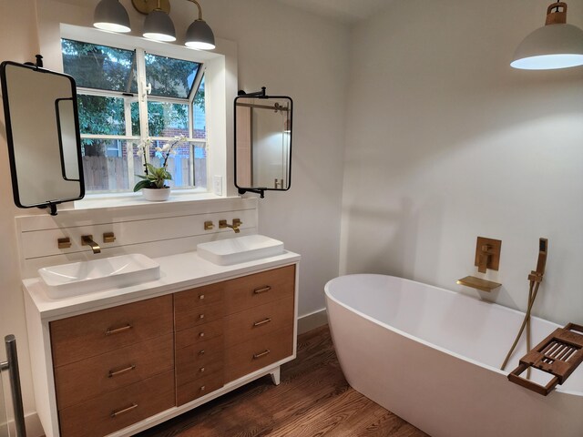 bathroom featuring vanity, wood-type flooring, and a tub