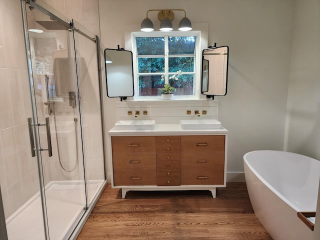 bathroom featuring wood-type flooring, vanity, and shower with separate bathtub