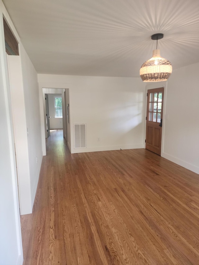 interior space with wood-type flooring, a wealth of natural light, and an inviting chandelier