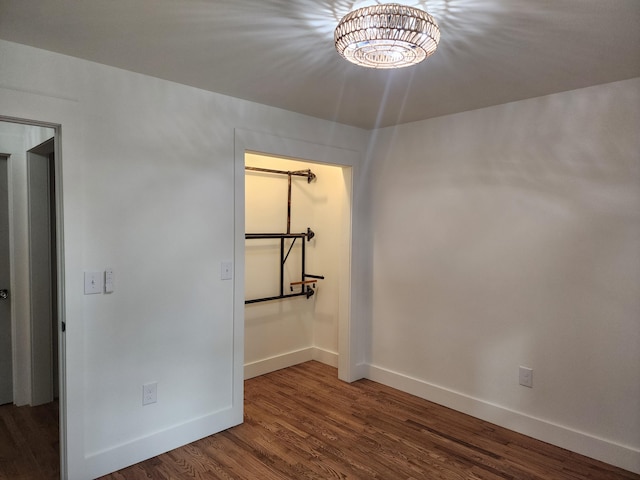 unfurnished room featuring dark hardwood / wood-style floors and a notable chandelier