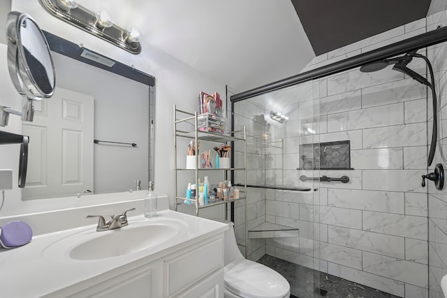 bathroom featuring vanity, a shower with shower door, and toilet