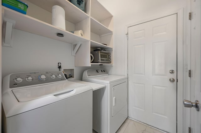 clothes washing area featuring separate washer and dryer