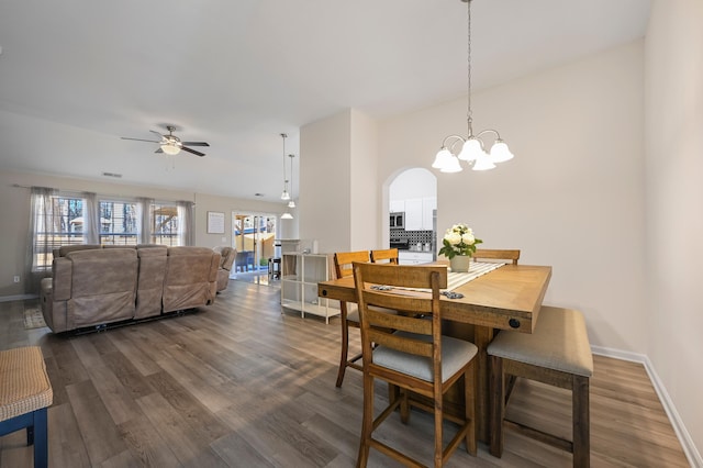 dining area with ceiling fan, a wealth of natural light, and dark hardwood / wood-style flooring