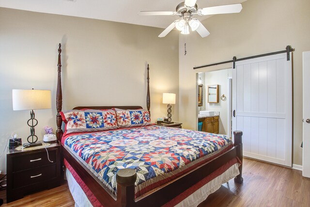 7896 Montview Rd, North Charleston, SC 29418 - bedroom featuring a barn door, wood finished floors, a high ceiling, ensuite bath, and a ceiling fan