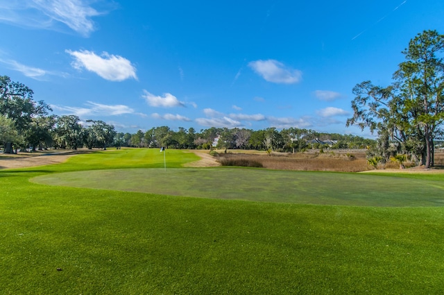 view of community with golf course view and a yard