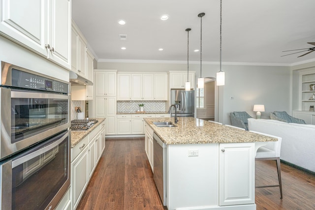 kitchen with under cabinet range hood, stainless steel appliances, dark wood-type flooring, and open floor plan