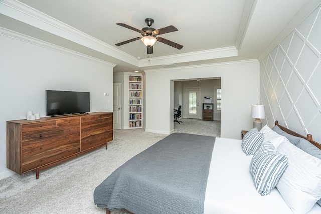 carpeted bedroom featuring a ceiling fan, a raised ceiling, and crown molding