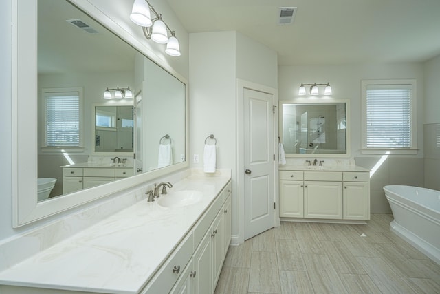 full bath featuring visible vents, a sink, and a tile shower