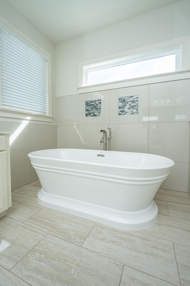 full bathroom with a freestanding bath and tile walls