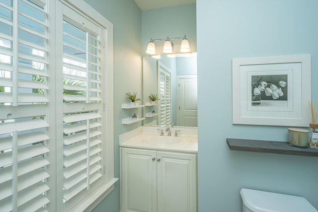 half bathroom featuring vanity and toilet